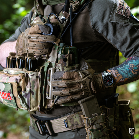 Person wearing tactical gear with a focus on gloves and equipment